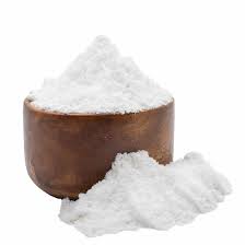 Fine white coconut powder in a wooden bowl and loose powder sample